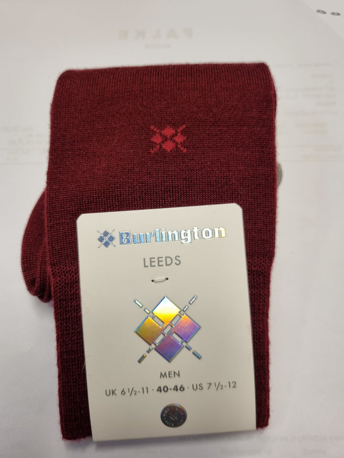 A folded pair of burgundy knit socks with a small red embroidered logo, attached to a white paper tag that reads 'Burlington LEEDS MEN'.
