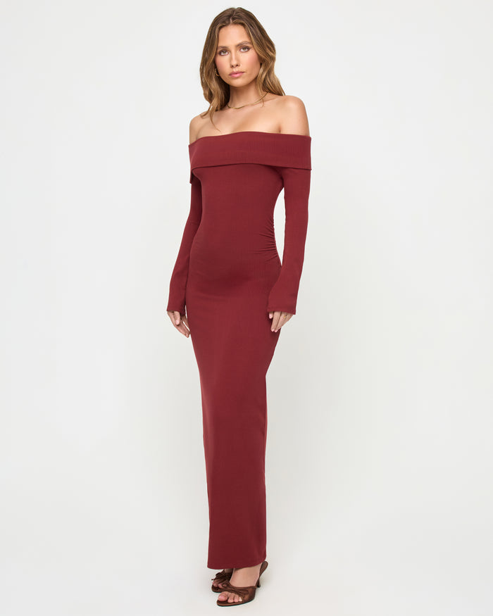 Front view of a model wearing the LSPACE Carrie Dress in sangria, featuring the off-the-shoulder folded neckline band, long sleeves with thumb holes, and body-hugging maxi silhouette in ribbed sangria knit fabric.