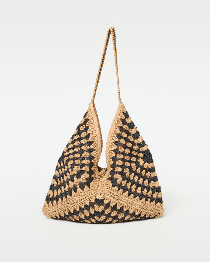 Off-model side view of the natural black Coastline Beach Bag showing its single shoulder strap.