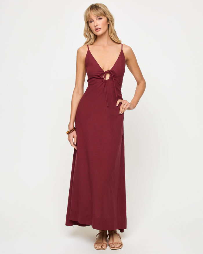 Front view of a model wearing the LSPACE Mabel Maxi Dress in sangria, featuring thin spaghetti straps, a deep V-neckline with keyhole cutout and tie detail at the bust, and a flowing full-length silhouette.