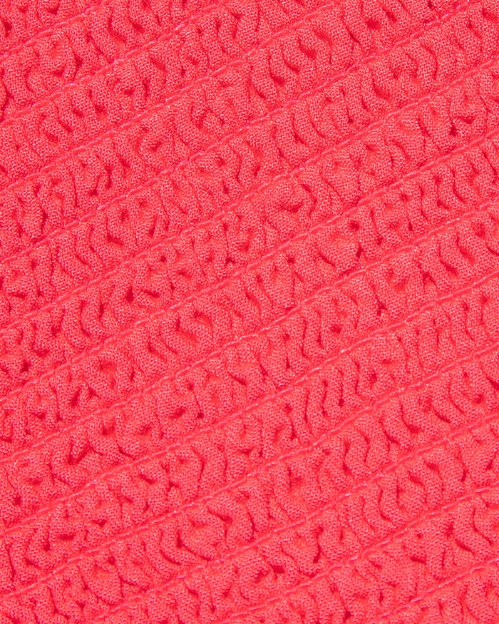 Close-up of the LSPACE Misha Midi in pout, showcasing the textured fabric in coral pink.
