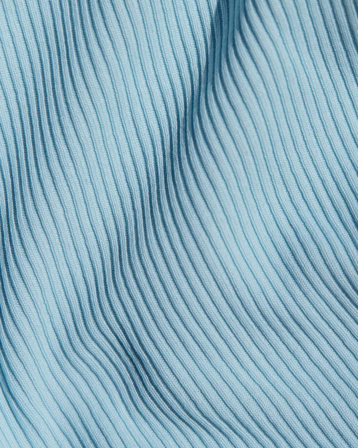 A close-up of a light blue ribbed knit fabric.