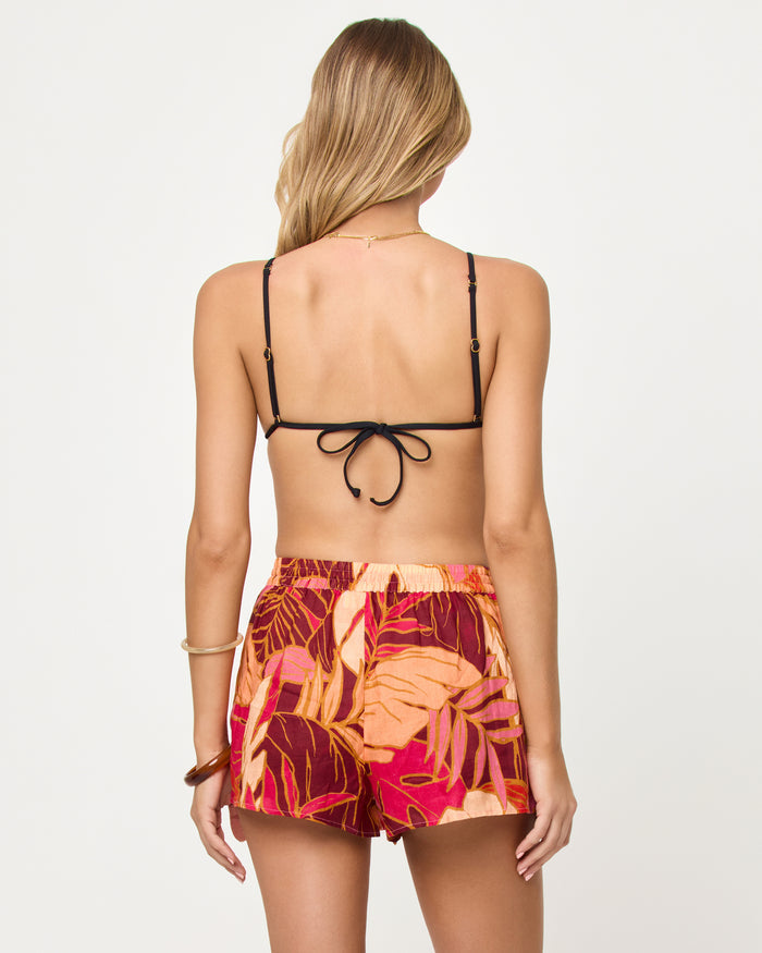 Back view of model wearing the LSPACE Rio Short in leaf it to me, a leaf-print drawstring short.