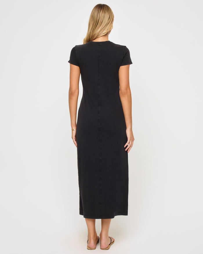 Back view of a model wearing the LSPACE Sloane Dress in black, showing the clean fitted back of the maxi dress with short sleeves.